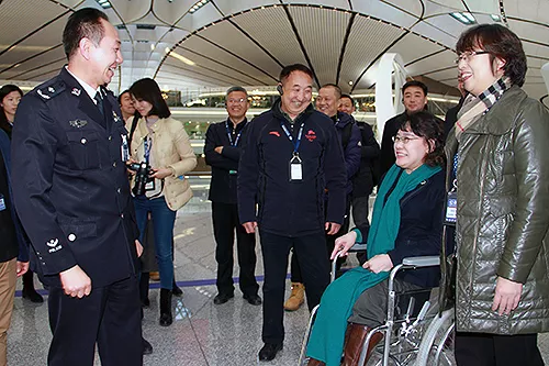 圖為張海迪與機(jī)場工作人員交談